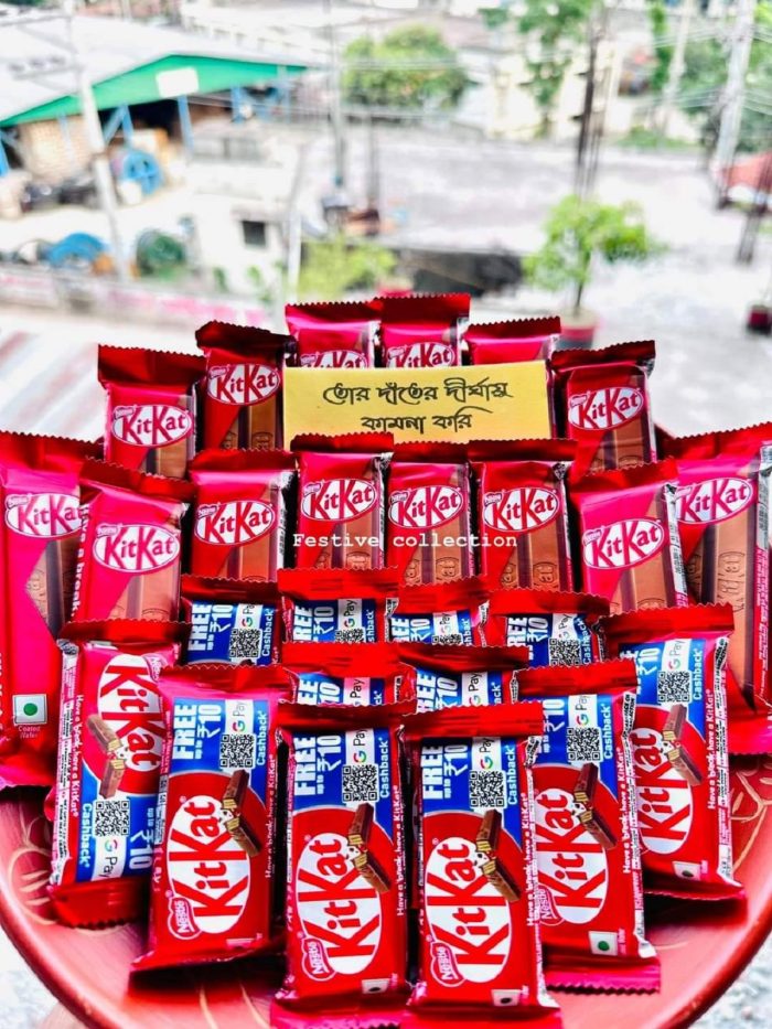 Festive KitKat chocolate arrangement with Bengali handwritten greeting card in a red tray – ideal for gifts and celebrations